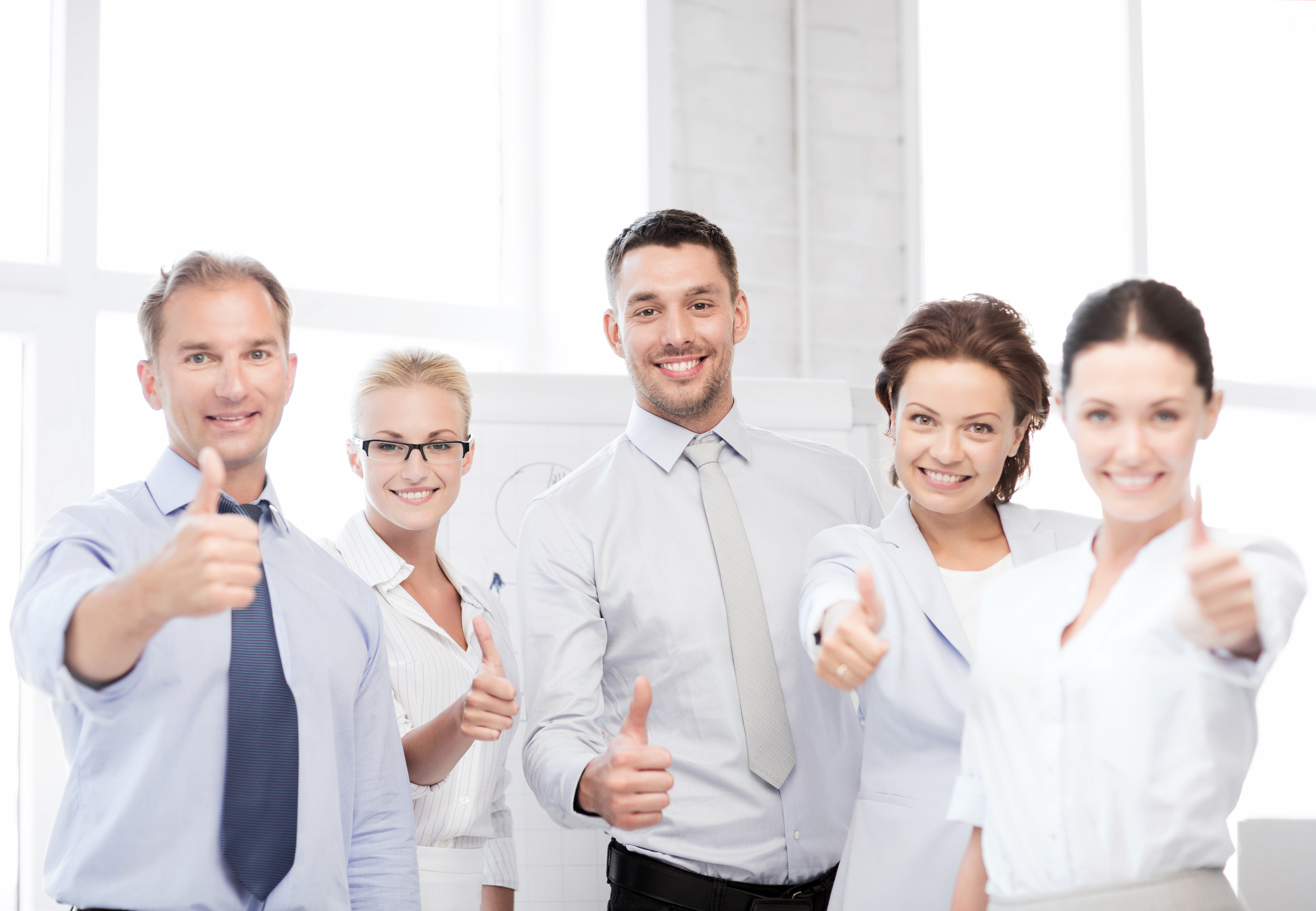 business team showing thumbs up in office