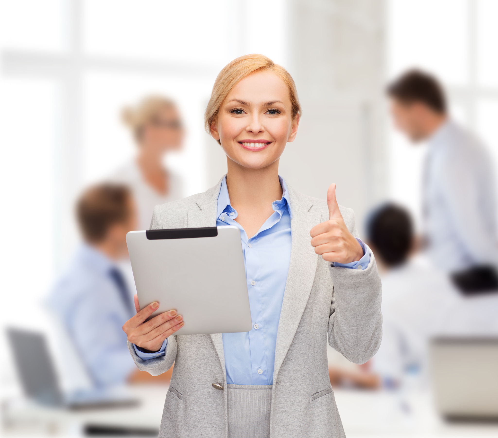 smiling woman with tablet pc showing thumbs up